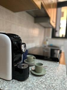 a coffee maker and two cups on a counter at Casa Ponturo in Taormina