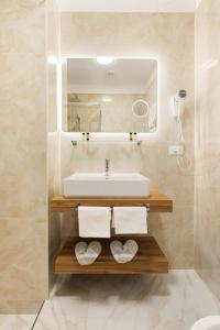 a bathroom with a sink and a mirror at AlbaDea Deluxe in Rome