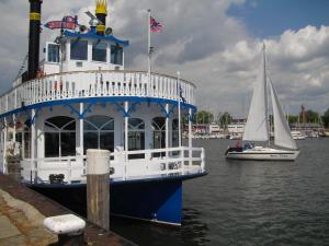 a blue and white boat in the water with a sailboat at Maisionette Wohnung im Hafenmeisterhaus Lauterbach in Lauterbach +13 photos