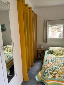 een slaapkamer met 2 bedden, een spiegel en een raam bij Chambre double cassis in Cassis