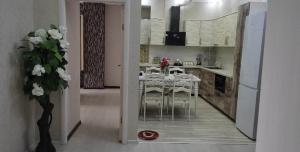 a kitchen with a table and chairs in a room at Квартира с хорошей энергетикой in Dushanbe