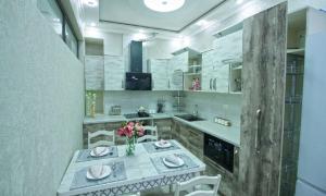 a kitchen with a table with a vase of flowers on it at Квартира с хорошей энергетикой in Dushanbe