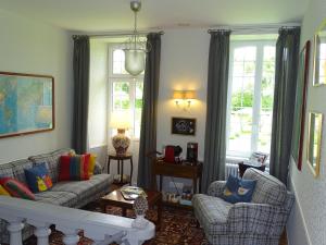 ein Wohnzimmer mit einem Sofa und 2 Stühlen in der Unterkunft Manoir Saint Martin in Percy