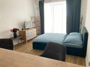 a bedroom with a bed and a desk and a window at Moderný apartmán A408 v centre NR, parkovanie v cene in Nitra