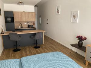 ニトラにあるModerný apartmán A408 v centre NR, parkovanie v ceneの部屋にカウンターと椅子2脚があるキッチン