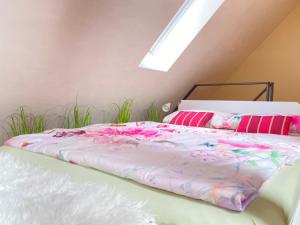 um quarto com uma cama com lençóis cor-de-rosa e almofadas cor-de-rosa em Apartment am Schloss em Brühl
