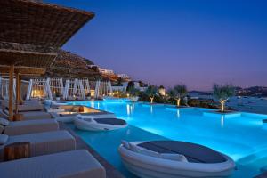 una piscina di acqua blu con dentro barche di Once in Mykonos - Designed for Adults a Ornos