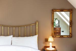a bedroom with a bed and a mirror at Railway Cottage in Killin