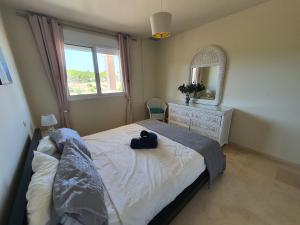 ein Schlafzimmer mit einem Bett, einem Spiegel und einem Fenster in der Unterkunft The Gaff in the Sun in Manilva