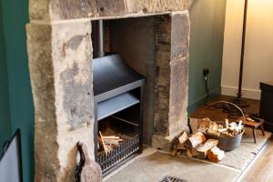 a stone fireplace in a living room at Railway Cottage in Killin