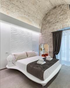 1 dormitorio con 1 cama grande y pared de ladrillo en Casa Massima Suites & SPA, en Casamassima