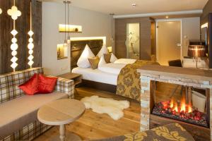 a hotel room with a bed and a fireplace at Hotel Das Rübezahl in Schwangau