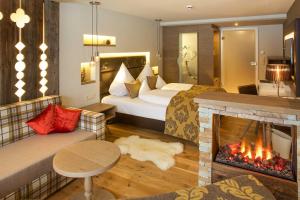 a hotel room with a bed and a fireplace at Das Rübezahl - Romantic Hideaway & Boutique Spa in Schwangau