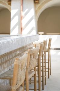 une rangée de chaises alignées sur un mur dans l'établissement Le Couvent des Minimes Hôtel & Spa L'Occitane, à Mane
