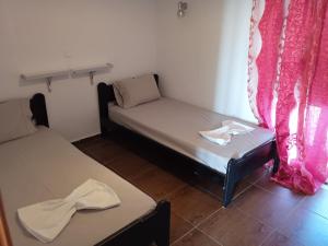 two beds in a room with pink curtains at Denise Villa in Platánion