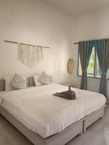 a bedroom with a large white bed with blue curtains at Kacchapa Beach Resort and Restaurant in Sekongkang