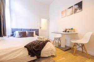 Habitación blanca con cama y escritorio en Cozy apartment in city center, en Praga