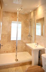 een badkamer met een bad, een wastafel en een douche bij Holmlea in Mickleton