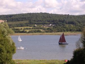 two boats on a lake with a red sail at Au gré des marées, 2 chambres avec petit déjeuner in Hanvec +6 photos