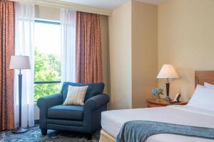 a hotel room with a bed and a chair and a window at Wellsworth Hotel in Southbridge