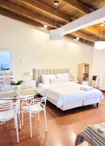 1 dormitorio con 1 cama grande, mesa y sillas en "Casa Amalia Apartamentos" Ubicación Privilegiada con Jardín en Mendoza