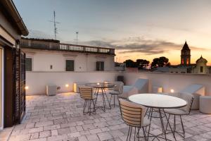 un patio con mesas y sillas y una torre de reloj en Casa Massima Suites & SPA, en Casamassima