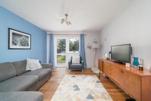 a living room with a couch and a flat screen tv at ALTIDO Cosy flat in Elephant and Castle, private garden and pets allowed in London