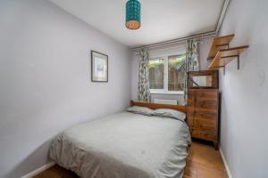 a small bedroom with a bed and a window at ALTIDO Cosy flat in Elephant and Castle, private garden and pets allowed in London