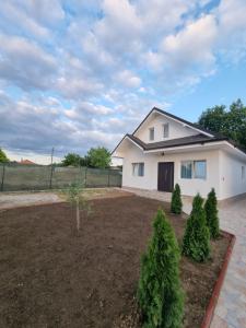 una casa blanca con árboles en un patio en CAZARE EDI, en Corbu