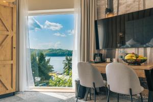 eine Küche mit einem Tisch und Stühlen sowie einem großen Fenster in der Unterkunft Sztygarka Hetmańska Resort Solina in Solina