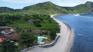 an aerial view of a beach with houses and the ocean at Kacchapa Beach Resort and Restaurant in Sekongkang