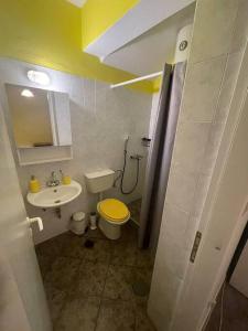 a small bathroom with a toilet and a sink at Yellow Beach House in Logaras