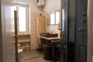 a small bathroom with a sink and a refrigerator at Vacanze Romane con giardino in Rome