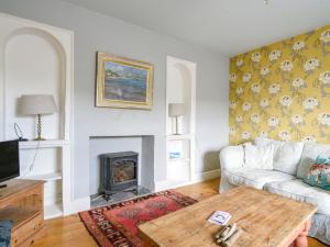 a living room with a couch and a fireplace at Thatched Cottage in Bridport