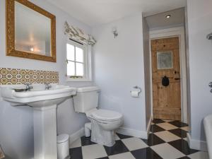 a bathroom with a toilet and a sink and a mirror at Thatched Cottage in Bridport +23 photos