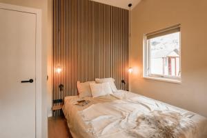 a bedroom with a large bed with a window at Mamooi Julianadorp in Julianadorp