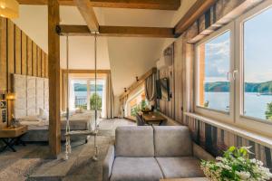 a living room with large windows and a swing at Sztygarka Hetmańska Resort Solina in Solina