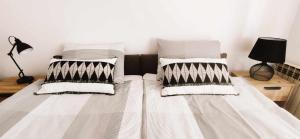 ein Bett mit schwarzen und weißen Kissen darauf in der Unterkunft Apartman Marija in Poreč