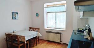 eine Küche mit einem Tisch und Stühlen sowie einem Fenster in der Unterkunft Apartman Marija in Poreč