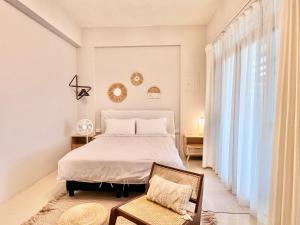 um quarto com uma cama, uma cadeira e uma janela em Brother Homestay em Taitung City
