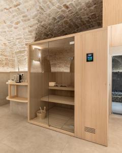 un armario de madera con puertas de cristal en una habitación en Casa Massima Suites & SPA, en Casamassima