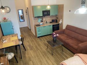 sala de estar con sofá, mesa y cocina en Štýlový apartmán A409 v centre NR, parkovanie v cene, en Nitra