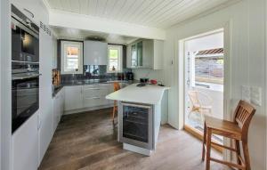 een keuken met witte kasten en een tafel en stoelen bij Cozy Home In ystese With House Sea View in Øystese