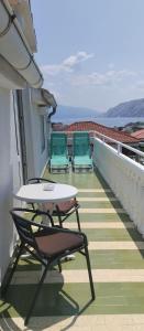 a patio with two chairs and a table on a balcony at Apartmani Gero in Lopar