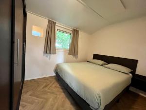 Schlafzimmer mit einem Bett und einem Fenster in der Unterkunft Landzicht Natuur Rust en Ruimte in Oosterwolde