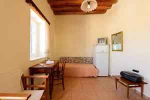 a living room with a table and a refrigerator at Ανώι - The Upper Storey in Kimolos