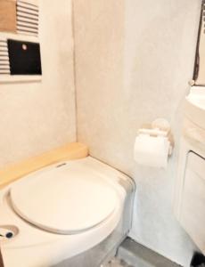 a small bathroom with a toilet and a roll of toilet paper at Love in the Camper in Florence