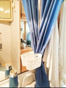 a bathroom with a blue curtain and a sink at Love in the Camper in Florence