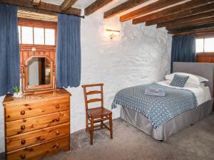 a bedroom with a bed and a dresser and a mirror at Y Bwthyn in Betws-y-coed