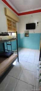 Zimmer mit 2 Etagenbetten und einem TV in der Unterkunft Rex Hotel in Marília